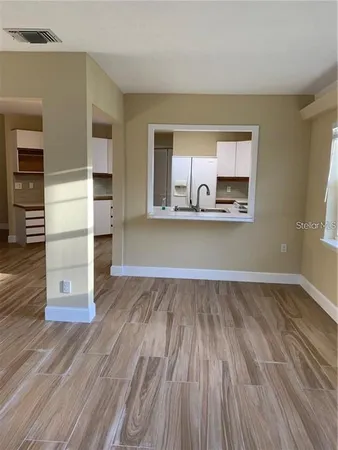 a view of a kitchen with wooden floor and electronic appliances