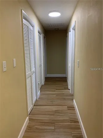 a view of a hallway with wooden floor and staircase