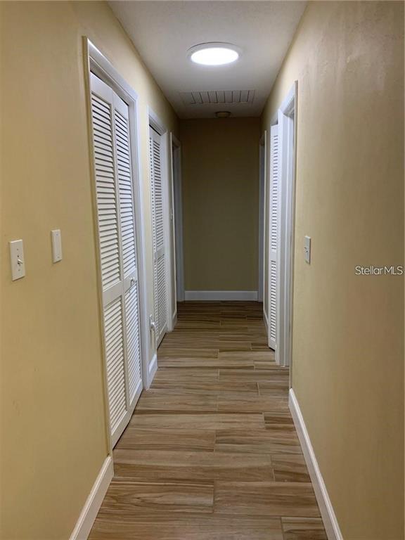 3090 Sunset Point Road Clearwater, FL 33759 - Photo 9 of 14 a view of a hallway with wooden floor and staircase