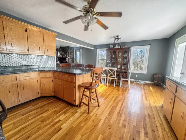 a dining room with wooden floor a chandelier a wooden table and chairs