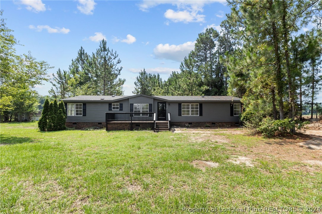 8002 Fayetteville Road Godwin, NC 28344 - Photo 1 of 40 a front view of a house with a yard and trees