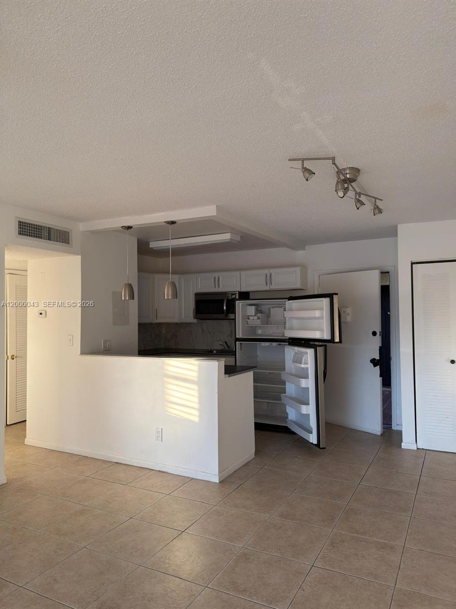 9108 Southwest 137th Street, Unit 163 Miami, FL 33176 - Photo 16 of 16 a kitchen with a stove and white cabinets