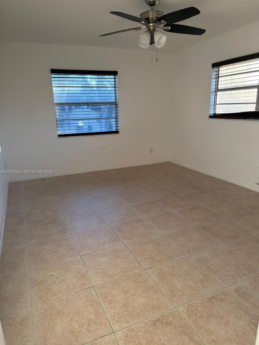 9108 Southwest 137th Street, Unit 163 Miami, FL 33176 - Photo 5 of 16 an empty room with windows and ceiling fan