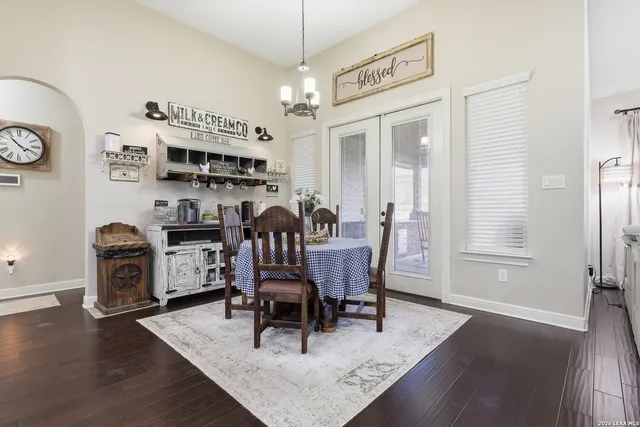 a dining room with furniture a chandelier and wooden floor