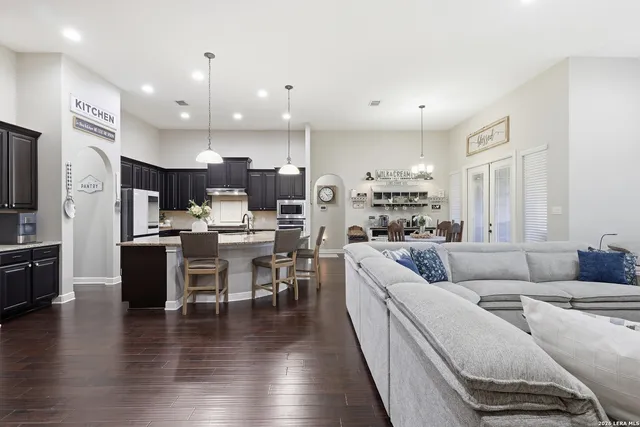 a living room with furniture kitchen and a wooden floor