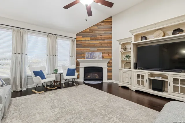 a living room with furniture a flat screen tv and a fireplace