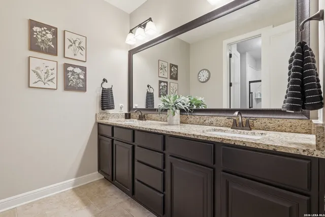 a bathroom with a granite countertop sink and a mirror