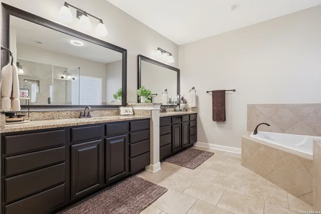 a spacious bathroom with a tub a mirror and a shower