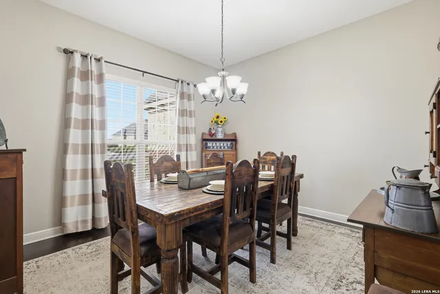 a dining room with furniture a chandelier and window