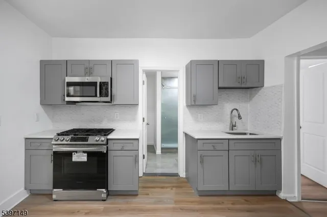a kitchen with stainless steel appliances a stove microwave and sink