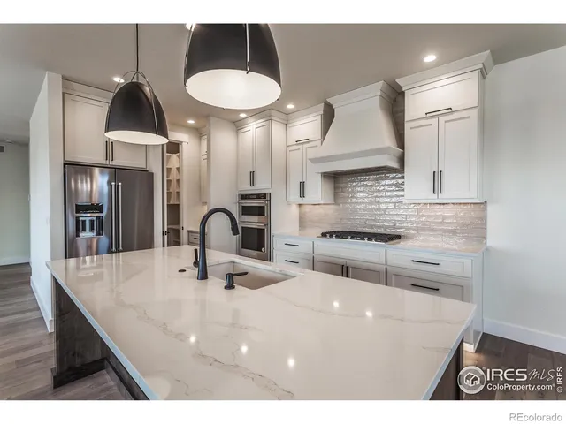a kitchen with a sink a stove and chairs