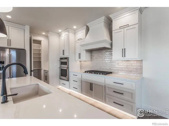 a kitchen with stainless steel appliances granite countertop a sink a stove and a refrigerator