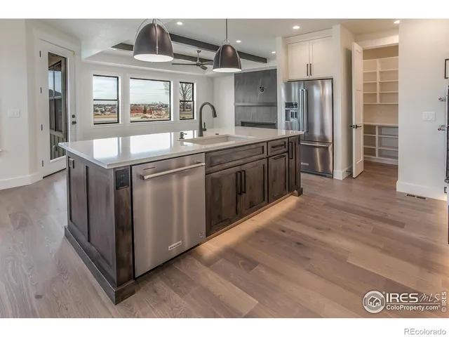 a kitchen with stainless steel appliances granite countertop a sink a stove a refrigerator and island