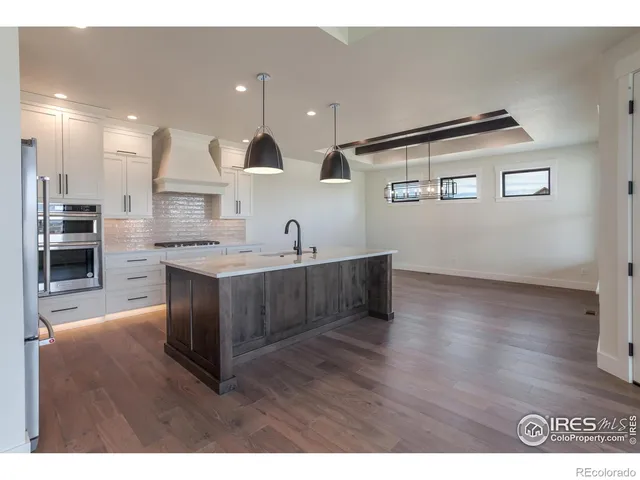 a kitchen with kitchen island a sink stainless steel appliances and cabinets