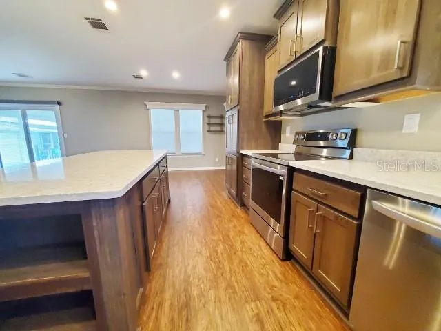 a kitchen with stainless steel appliances granite countertop a sink a stove and a refrigerator