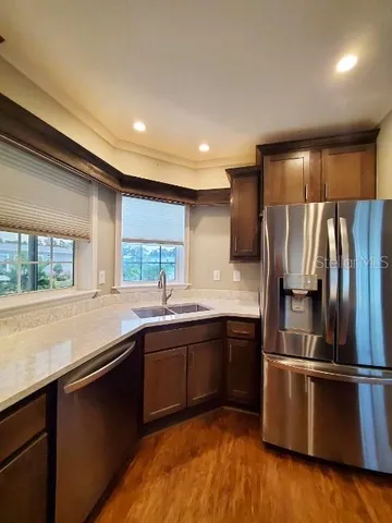 a kitchen with stainless steel appliances granite countertop a sink a stove and a refrigerator