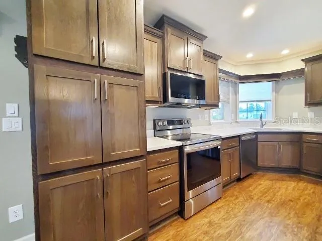 a kitchen with stainless steel appliances granite countertop a refrigerator a sink a stove top oven and a refrigerator