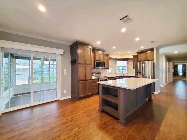 a large kitchen with stainless steel appliances granite countertop a large counter top and a large window