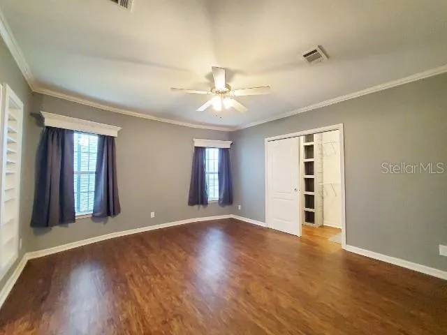a view of an empty room with window and wooden floor