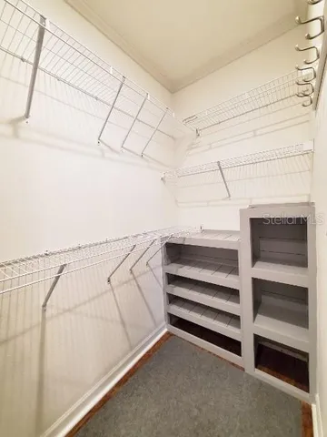 a view of walk in closet with empty racks