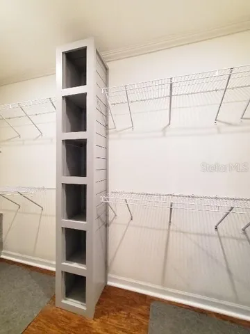 a view of walk in closet with empty racks