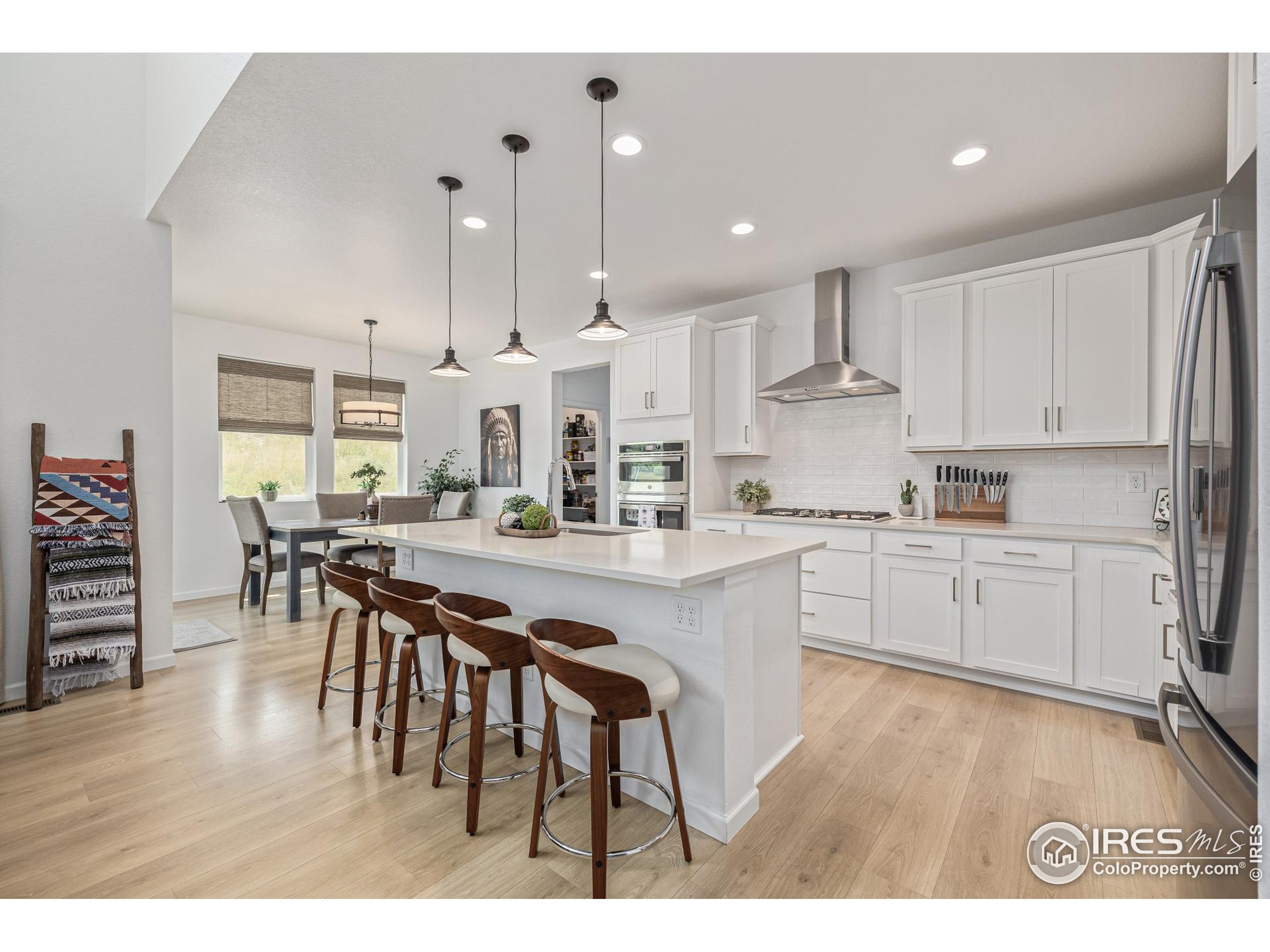 3624 Rucksack Court Castle Rock, CO 80108 - Photo 21 of 50 a kitchen with stainless steel appliances kitchen island granite countertop a table chairs sink and cabinets