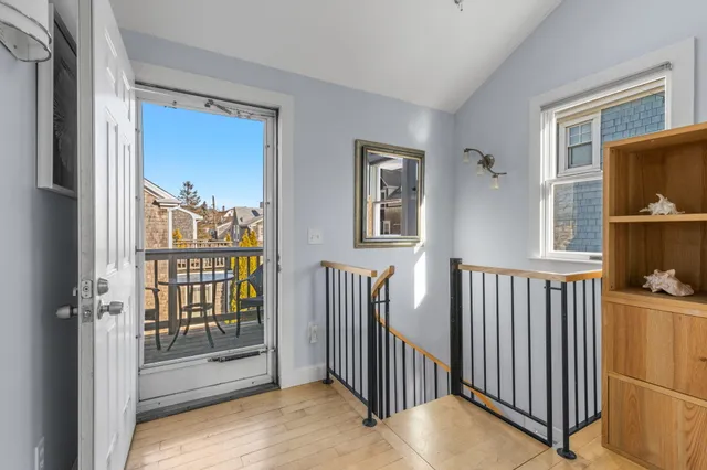 a view of a hallway with wooden floor and windows