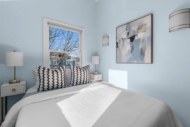 a bedroom with a bed and a painting on the wall