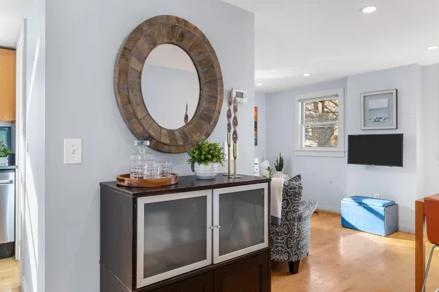a living room with furniture a mirror and a flat screen tv