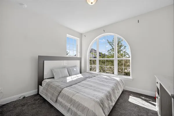 a bedroom with a large bed and a window