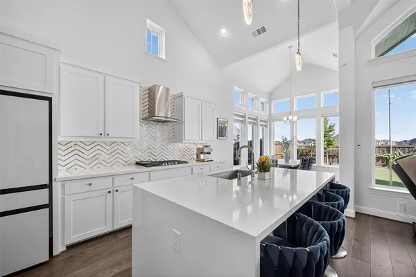 a kitchen with a sink a stove and chairs