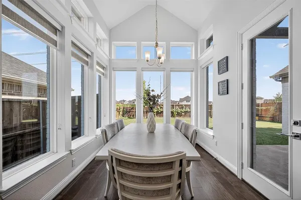 a view of a dining room with furniture a chandelier and wooden floor