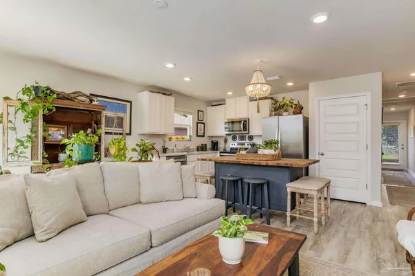 a living room with stainless steel appliances kitchen island granite countertop furniture and a couch