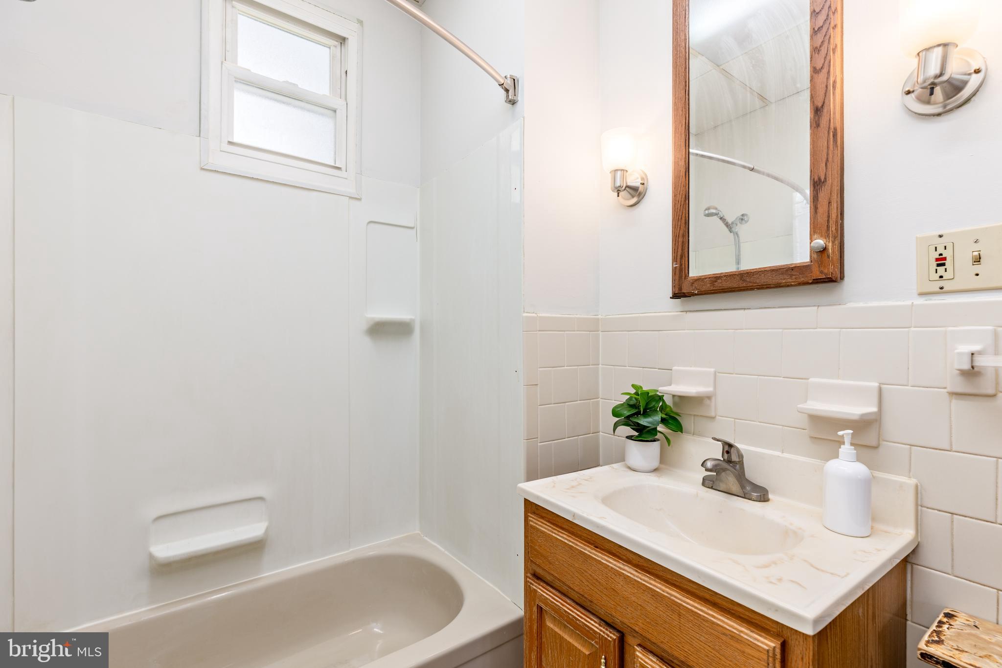 6426 Sherwood Road Baltimore, MD 21239 - Photo 21 of 43 a bathroom with a sink a toilet and a mirror