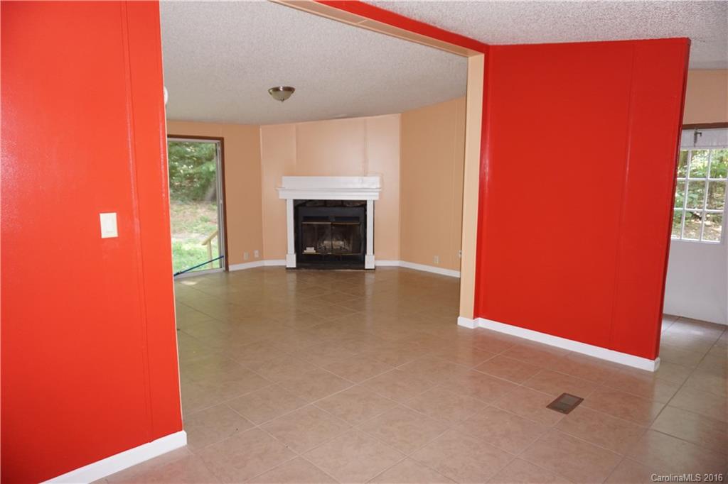 7385 Tuckaseegee Road Kannapolis, NC 28081 - Photo 2 of 14 a view of an empty room with a fireplace and a window