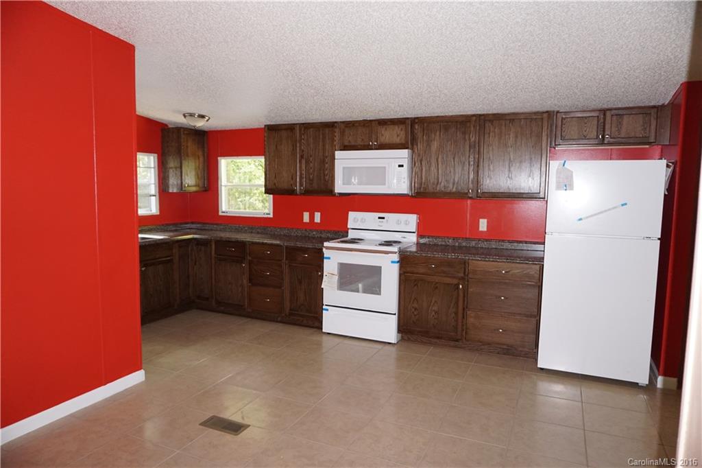 7385 Tuckaseegee Road Kannapolis, NC 28081 - Photo 3 of 14 a kitchen with stainless steel appliances granite countertop a stove a sink and a refrigerator