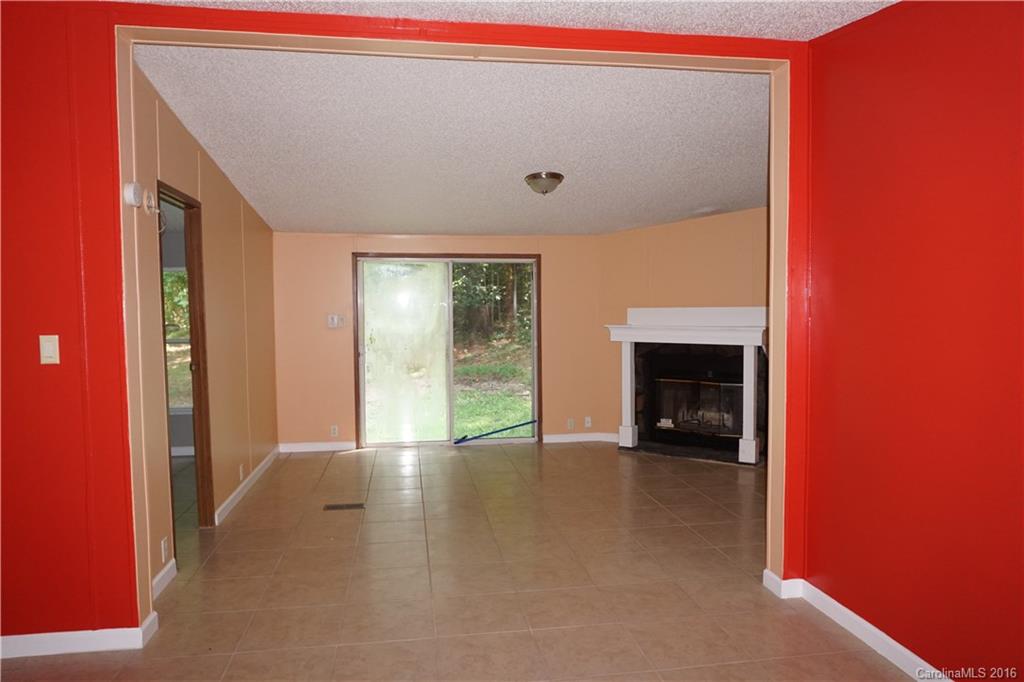 7385 Tuckaseegee Road Kannapolis, NC 28081 - Photo 4 of 14 a view of an empty room with a fireplace and a window
