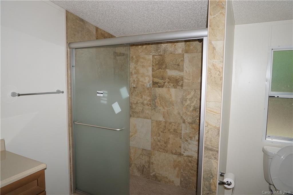 7385 Tuckaseegee Road Kannapolis, NC 28081 - Photo 8 of 14 a bathroom with a glass shower door