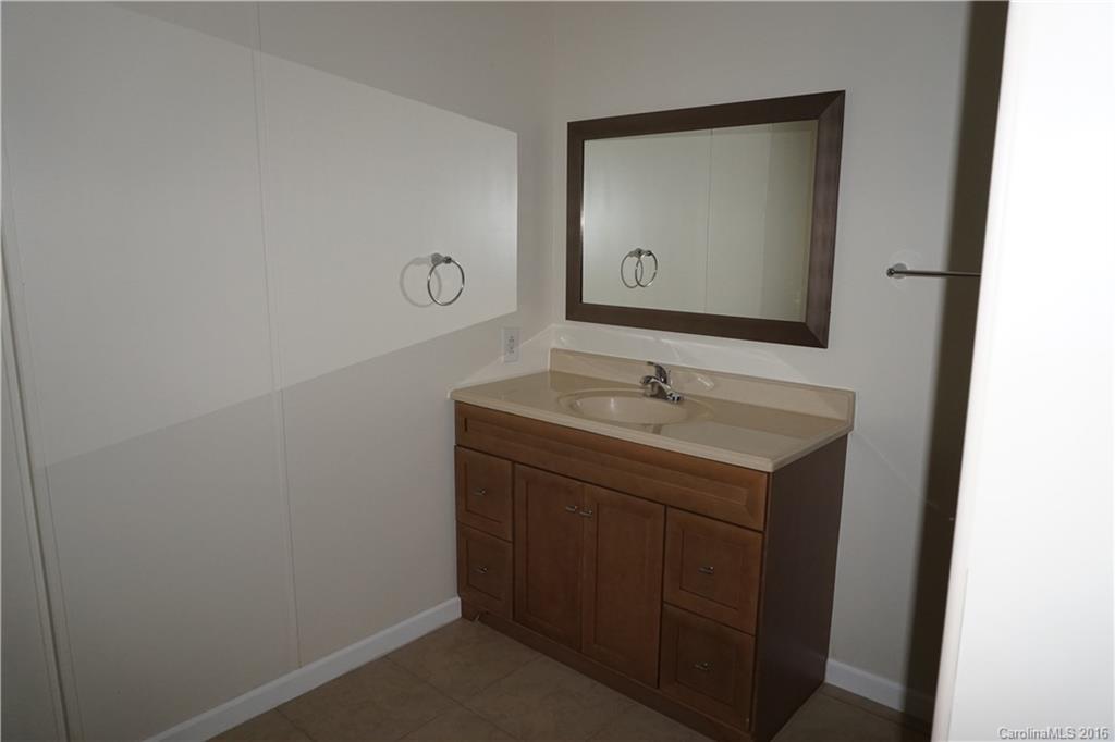 7385 Tuckaseegee Road Kannapolis, NC 28081 - Photo 9 of 14 a bathroom with a sink vanity and a mirror