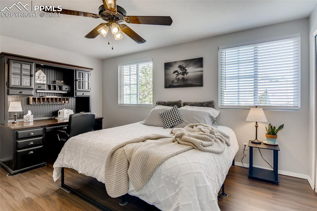 7330 Julynn Road Colorado Springs, CO 80919 - Photo 14 of 28 a bedroom with a bed and a chandelier