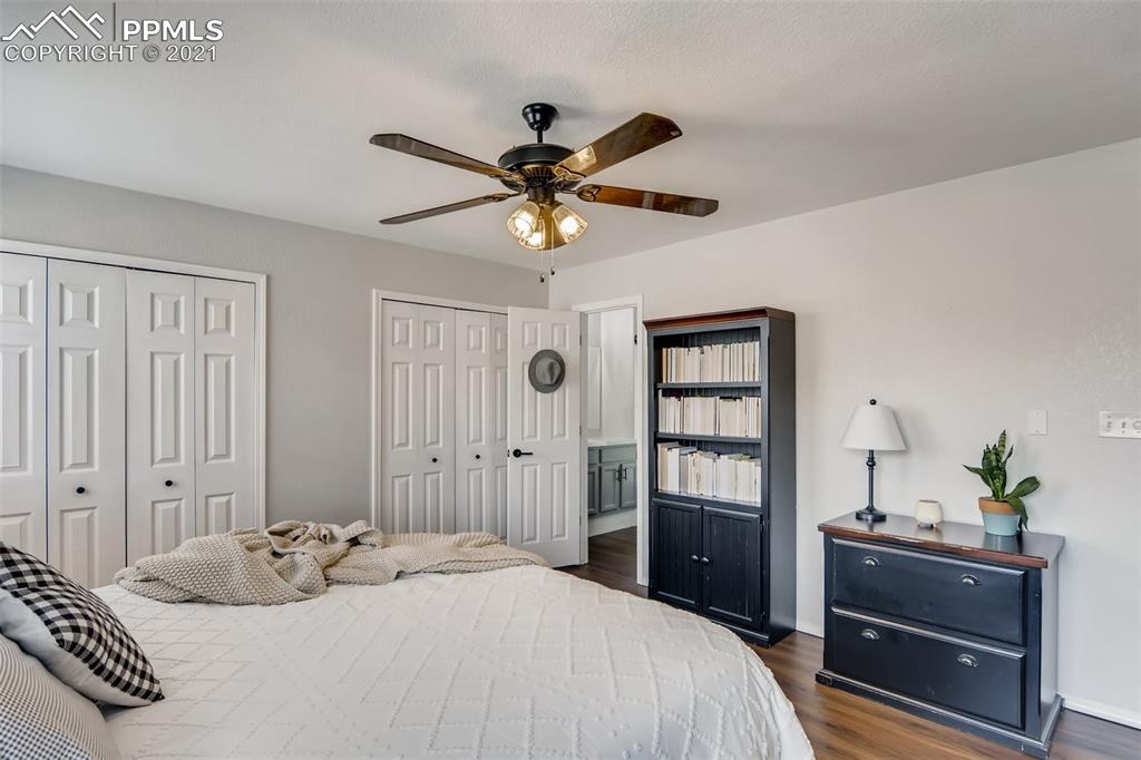 7330 Julynn Road Colorado Springs, CO 80919 - Photo 16 of 28 a bedroom with a bed and a chandelier