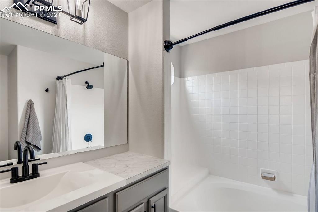 7330 Julynn Road Colorado Springs, CO 80919 - Photo 17 of 28 a bathroom with a shower and a mirror
