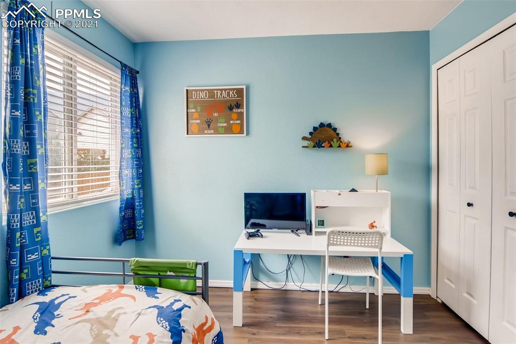 7330 Julynn Road Colorado Springs, CO 80919 - Photo 20 of 28 a bedroom with a bed and a table in it