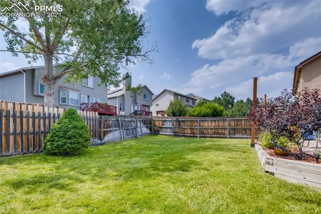 7330 Julynn Road Colorado Springs, CO 80919 - Photo 28 of 28 a view of a garden with a house in the background