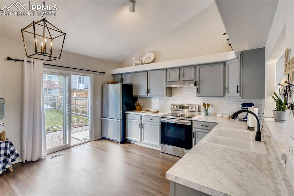 7330 Julynn Road Colorado Springs, CO 80919 - Photo 6 of 28 a kitchen with refrigerator cabinets and wooden floor
