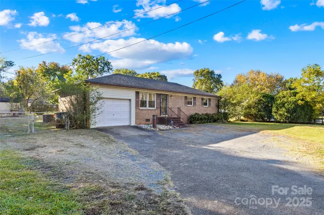 a view of a house with backyard and a tree