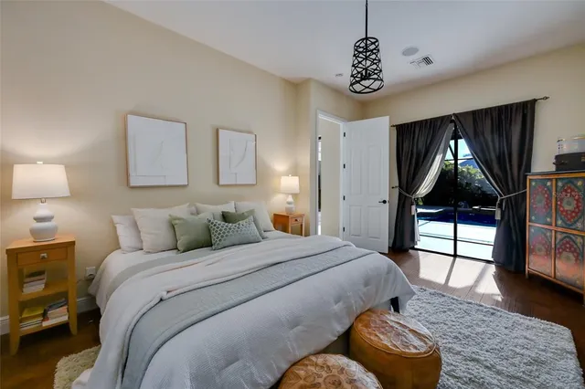 a bedroom with a bed mirror and window