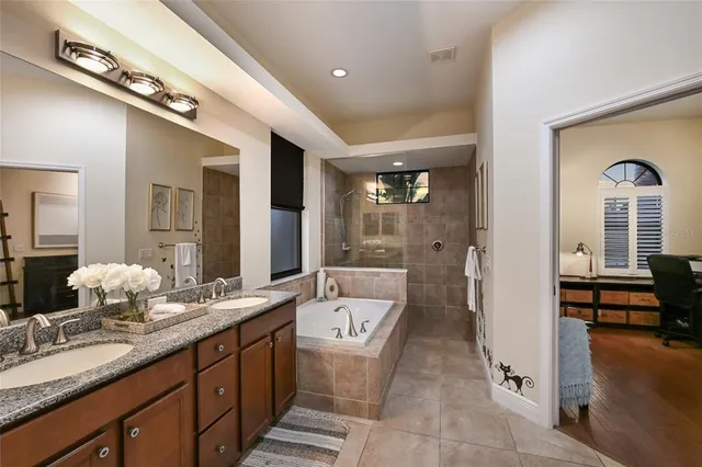 a bathroom with a double vanity sink a toilet and shower