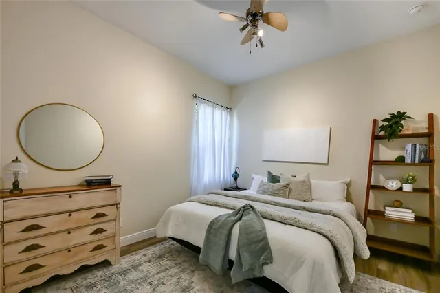 a bedroom with a bed a mirror and a dresser