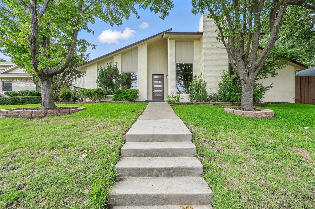 a front view of a house with a yard and an trees